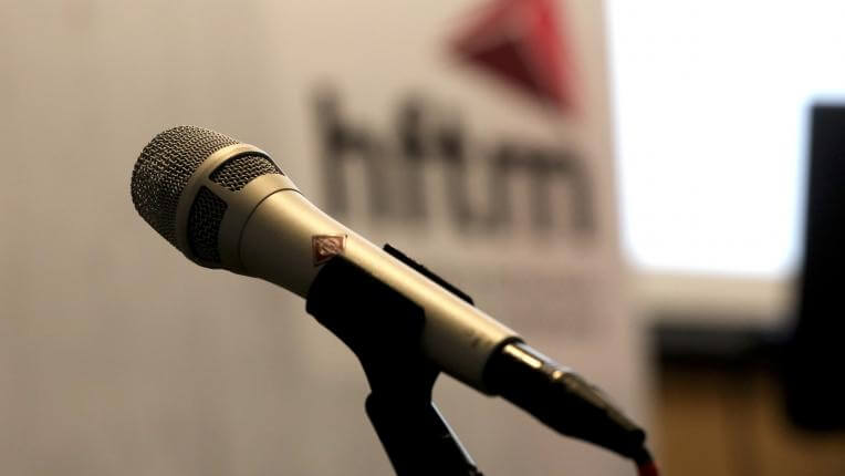 Diplomfeier Techniker HF Biel - Mikrophon vor hftm Logo
