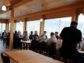 Teilnehmende frühstücken und tauschen sich beim Netzwerkanlass Müesli 4.0 mit Blick auf den Bielersee aus