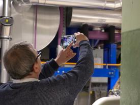 Teilnehmer fotografiert technische Anlage während der Führung beim Anlass Müesli 4.0