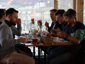 Teilnehmende frühstücken beim Netzwerkanlass Müesli 4.0 mit Blick auf den Bielersee