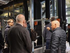 Gruppe betrachtet Rohrleitungen und Energieanlagen beim Rundgang durch den Energieverbund Bielersee