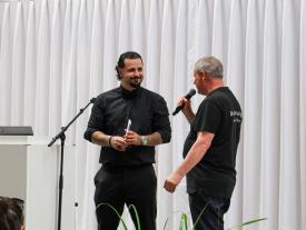 Student und Fachbereichsleiter auf der Bühne der hftm Diplomausstellung