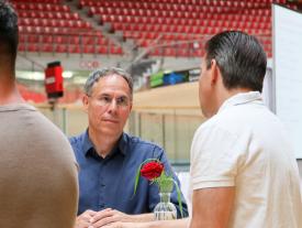 Besucher im Fachgespräch an einem Stehtisch der hftm Diplomausstellung im Velodrom