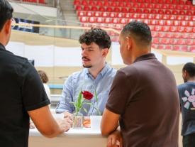 Diplomand im Gespräch mit Gästen am Stehtisch der hftm Diplomausstellung 2026 im Velodrom