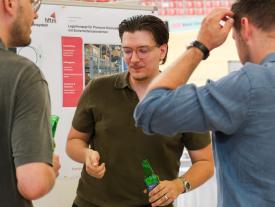Diplomand im Gespräch vor einer Logistik-Diplomarbeit der hftm im Velodrom Grenchen