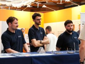 Aussteller am Frisa-Stand beraten Besucher an der hftm Diplomausstellung im Velodrom