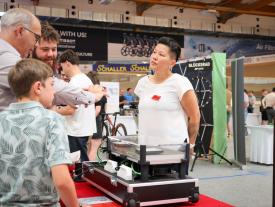 Ausstellerin erklärt Gästen ein technisches Modell an der hftm Diplomausstellung im Velodrom