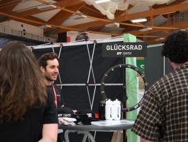 Aussteller am DT Swiss Glücksrad im Gespräch mit Gästen der hftm Diplomausstellung