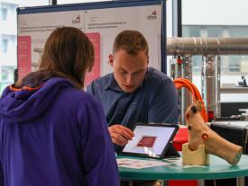 Besucher im Gespräch mit Studierenden an der hftm Diplomausstellung in Biel.