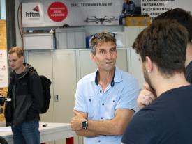"Dozent im Gespräch mit Studierenden an der hftm Diplomausstellung in Biel