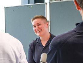 Studentin erklärt ihr Projekt und lächelt an der hftm Diplomausstellung Biel
