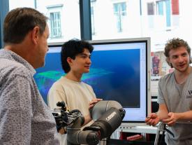 Studierende diskutieren Robotikprojekt mit Besucher an der hftm Diplomausstellung Biel
