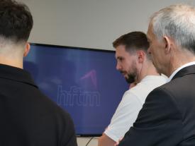 Studierende erklären ihr Drohnenprojekt vor Bildschirm an der hftm Diplomausstellung Biel