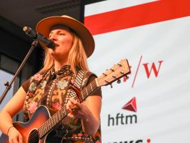 Musikerin singt mit Gitarre an der hftm Diplomfeier Wirtschaftsinformatik
