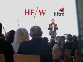 Moderator spricht vor Publikum an der hftm Diplomfeier Wirtschaftsinformatik